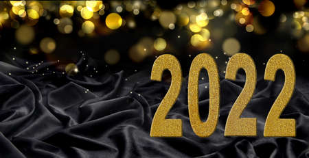 2022 greeting card with year written with golden figures on dark fabric and blur lights backgroundの写真素材