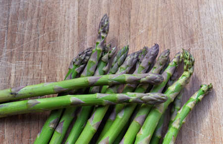 heap of green raw asparagus put on a wooden tableの写真素材