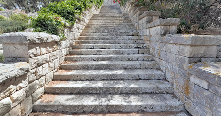 stone steps of an outdoors straicase going up very high in a park of Puglia in Italy