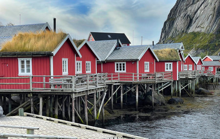 Picturesque red cabins on stilts at the edge of the sea in the village Reine in Lofoten Islands; Northern Norwayの写真素材