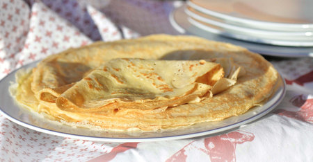 traditional french pancake homemade - folded crepe in a plate on a red and white tableclothの写真素材