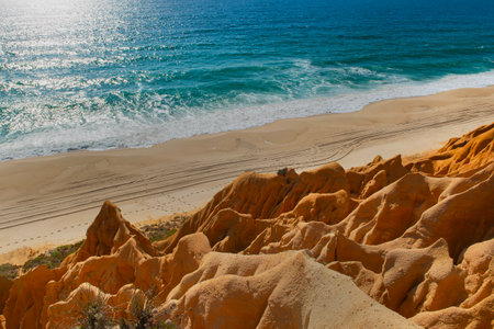 beautiful beach in the Atlantic Ocean bordered by hard sand cliffs forming a canyon Medides beach in Portugalの写真素材