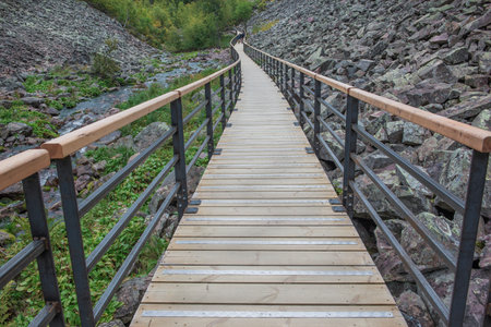 wooden footbridge with guardrail crossing a rocky valley in a sweden national park FulufjÃ¤llet,の写真素材