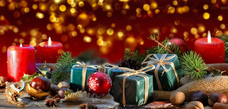 traditional christmas decoration on a table witjh candles and gifts and golden blur lights backgroundの写真素材