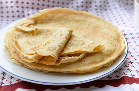 traditional french pancake homemade- folded crepe in a plate on a red and white tableclothの写真素材