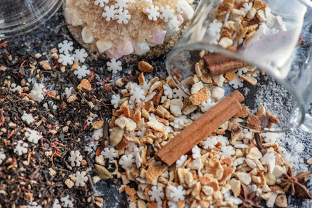 top view on heap of winter hot drink ingredient spilled on table with stick of cinnamon and sugar star shapeの写真素材