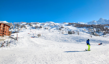 view on ski slope in tarentaise ski resort in beautiful snowy landscape under blue skyの写真素材
