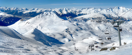 beautiful view on snowy mountain range and ski lift in the French Alps in Tarentaise resort under blue skyの写真素材