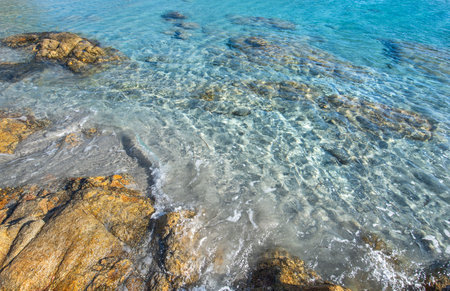 beautiful water transparent and blue of a sea in a Sardinia beach with granite rockの写真素材