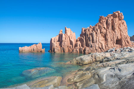red granite rock on the edge of a the clear sea in Sardinia Italy - Rocce Rosse Arbataxの写真素材