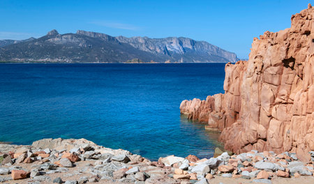 red granite rock on the edge of a the clear sea in Sardinia Italy - Rocce Rosse Arbataxの写真素材
