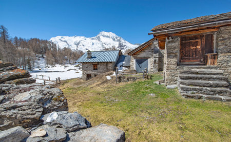 alpine empty village in tarentaise valley in Savoie france with old chalet and snowy mountain landscape backgroundの写真素材