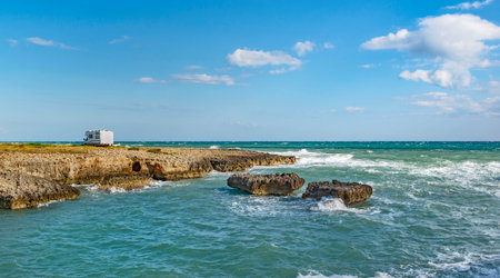 camper parked far away by the sea on a rock beachの写真素材
