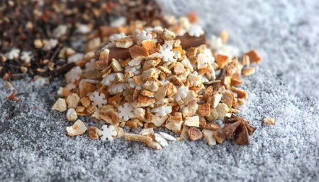 heap of sweet ingredients and spices for winter hot drink preparation on snowy backgroundの写真素材