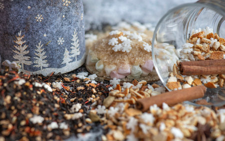 winter hot drink ingredient spiced with spices, star-shaped and sugar and glass cup turn over on snowy backgroundの写真素材