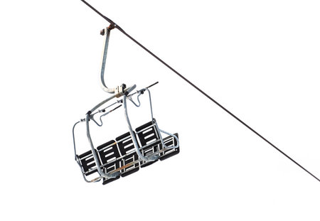 empty ski lift chair suspended on cable and isolated on white background