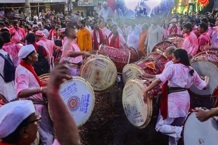 A selective focus image of a group of devotees  dancing on the beat of drums during the festival of an Indian God Ganesh at Pune Maharasthra India on 12 September 2019のeditorial素材