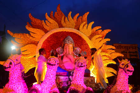 Idol of Indian God Ganesh beautifully decorated with flowers and lights being taken for Emerson in water at pune Maharasthra India on 12 September 2019のeditorial素材