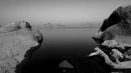 A selective focus image of a  landscape of Jawai dam with the  Aravalli mountain ranges with its reflection in water at Jawai in Rajasthan  Indiaの写真素材