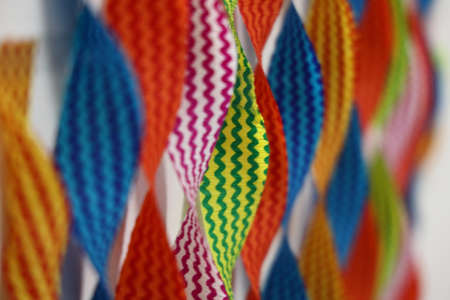 A shallow depth of field macro image  of colorful ribbons with only yellow and green stripe ribbon in focus with blur foreground and background  as abstractの写真素材