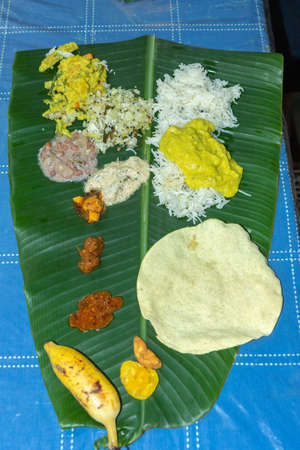 Traditional Kerala food laid out on a banana leaf during the Onam festival in Kerala Indiaの写真素材