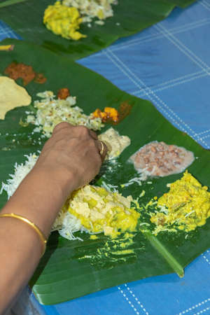 Traditional Kerala food being eaten on a banana leaf during the Onam festival in Kerala Indiaの写真素材