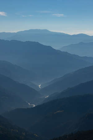 Silhouette of mountain ranges with a river flowing through them during an early morning at Sikkim Indiaの写真素材