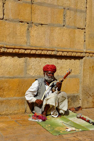 A man wearing turban is siting on ground and playing vilolin at Jaiselmer Rajasthan India on 21 February 2018のeditorial素材