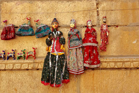 Colorful human shaped Puppets wearing colorful clothes hanging against the wall in Rajasthan India on 21 February 2018の写真素材