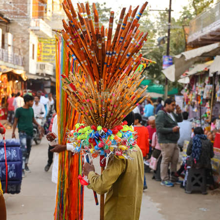A man selling flutes and plastic toys displayed on his shoulder on the streets of Pushkar,...