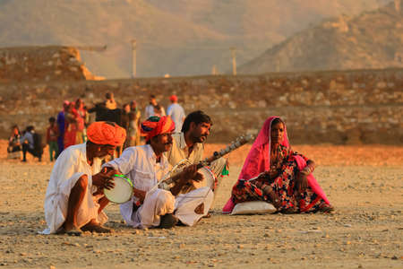 A group of people siting on ground and playing tradional Indian music instruments at Pushkar, Rajasthan, India on 19 November 2018のeditorial素材