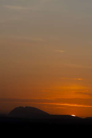 Silhouette of hills against beautiful golden hour sunset and beautiful orange skyの写真素材