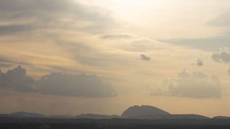 Silhouette of hills against beautiful golden hour light with wide angle and beautiful clouds formationの写真素材