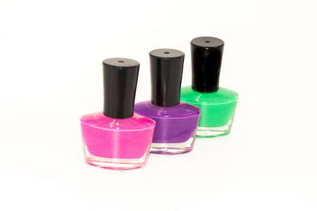 Shallow depth of field image of Three bottles of colored nail polish kept on display with white backgroundの写真素材