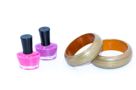 A pair of color nail polish bottles and green wooden banglesの写真素材