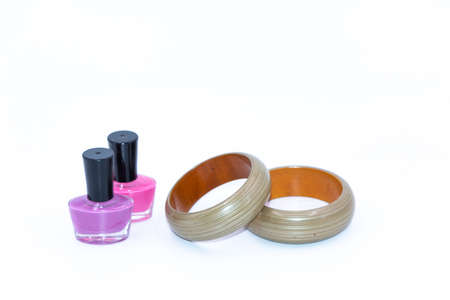 A pair of color nail polish bottles and green wooden banglesの写真素材
