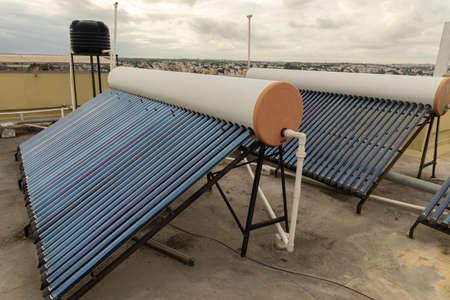 solar panels and tubes installed on roof top of houses and buildings to conserve energyの写真素材