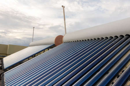 solar panels and tubes installed on roof top of houses and buildings to conserve energyの写真素材