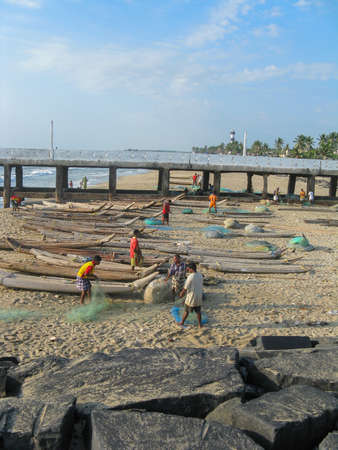 Fishermen at beach near their boats and preparing their fishing nets at Pondicherry Tamil nadu India on 8 October 2008のeditorial素材