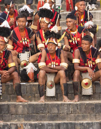 Selective focus image of Naga tribesmen  wearing their traditional attire and siting together in Kisama Village arena  in Nagaland India on 4 December 2016のeditorial素材