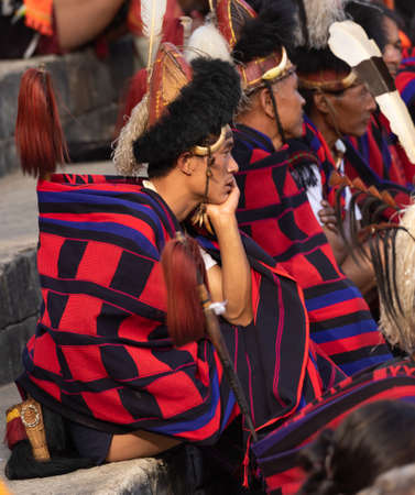 Selective focus image of Naga tribesmen  wearing their traditional attire and siting together in Kisama heritage Village arena  in Nagaland India on 4 December 2016のeditorial素材