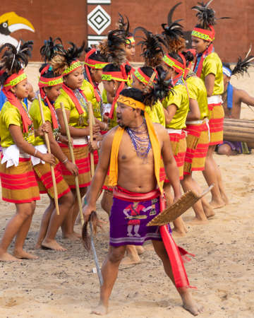 Selective focus image of a group of young Naga tribesmen playing their traditional music and dancing during Hornbill festival in Kisama village Nagaland India on 3 December 2016のeditorial素材