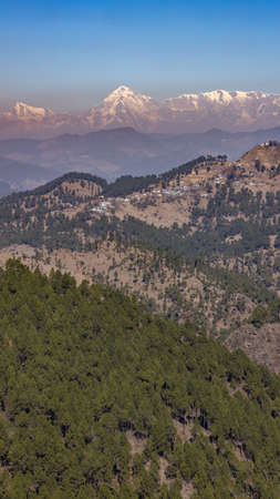 A view of the Nanda Devi peak on the Himalayan range with mountains with trees in the foregroundのeditorial素材