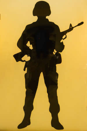 Silhouette of a soldier wearing a helmet and holding a weapon