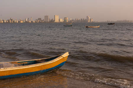 View of a fishing boat in the sea with the Marine drive skyline in the background at Mumbai India on 2 April 2021のeditorial素材
