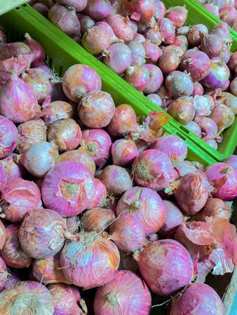 Heaps of raw organic onions kept in a basket in a market stallの写真素材