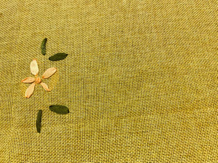 An abstract image if a brown cloth with with texture and flowers made on one sideの写真素材