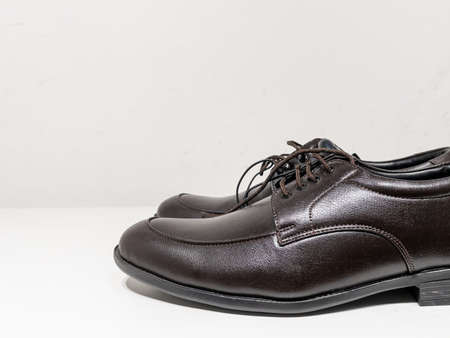 A pair of formal black shoes with laces displayed with white backgroundの写真素材