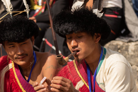 Portrait of a Naga Tribesman dressed in tribal Attire smoking a  pipe during Hornbill Festival in Nagaland India on 2 December 2016のeditorial素材