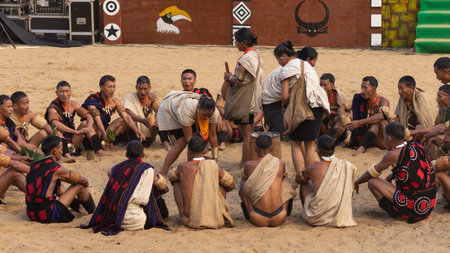 Selective focus image of Naga men and women siting and performing a traditional tribal ritual at a village in Nagaland India during hornbill festival on 4 December 2016のeditorial素材
